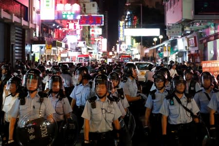 Riot police officers stand guard during a march against the extradition bill in Hong Kong's tourism district of Mongkok