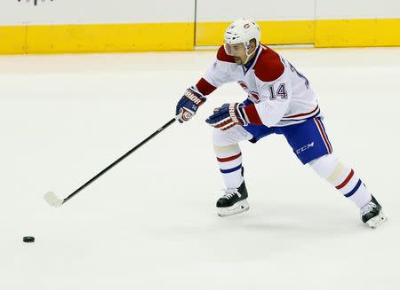 Oct 8, 2014; Toronto, Ontario, CAN; Montreal Canadiens forward Tomas Plekanec (14) reaches for a loose puck against the Toronto Maple Leafs at the Air Canada Centre. Mandatory Credit: John E. Sokolowski-USA TODAY Sports