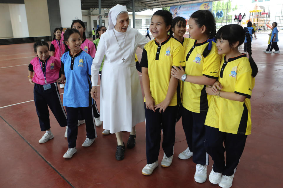 In this Aug. 27, 2019, photo, ST. Mary's School Vice Principal Sister Ana Rosa Sivori, center, talks to students during a lunch break at the girls' school in Udon Thani, about 570 kilometers (355 miles) northeast of Bangkok, Thailand. Sister Ana Rosa Sivori, originally from Buenos Aires in Argentina, shares a great-grandfather with Jorge Mario Bergoglio, who, six years ago, became Pope Francis. So, she and the pontiff are second cousins. (AP Photo/Sakchai Lalit)