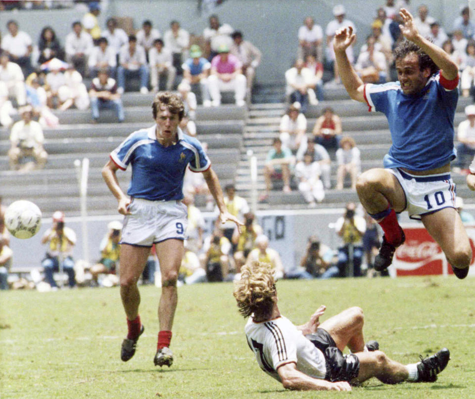 FILE - In this file photo dated June 25, 1986, France's Michel Platini, right, jumps over Germany's Ditmar Jakobs during the Football World Cup Semi-Final in Guadalajara, Mexico, with French defender Luis Fernandez, left. Affectionately nicknamed “Le Roi” (The King), Michel Platini bestrode the soccer field with inimitable elegance as the world’s best player of the early 1980s, but his lofty reputation seems to have been tainted. (AP Photo/Blaha, FILE)
