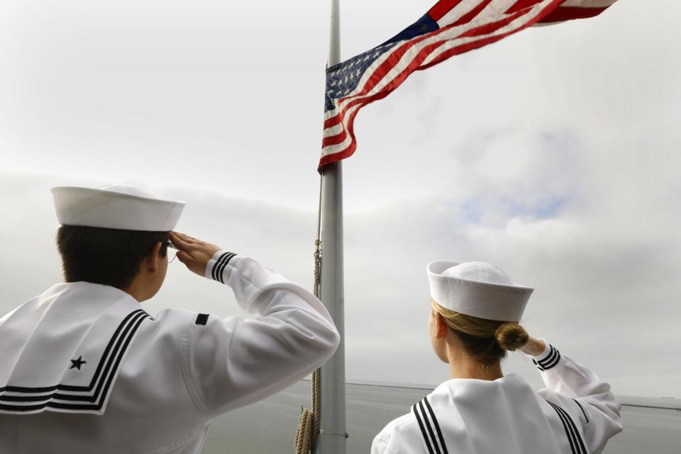 Sailors salute the colors