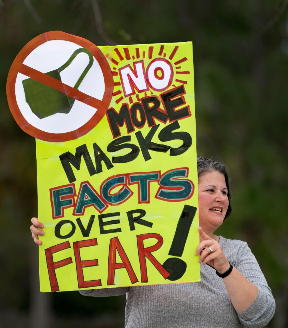 Anti-mask demonstrator Jennifer Showalter holds a sign outside the Palm Beach County School District offices during a school board meeting on April 21, 2021 in West Palm Beach.