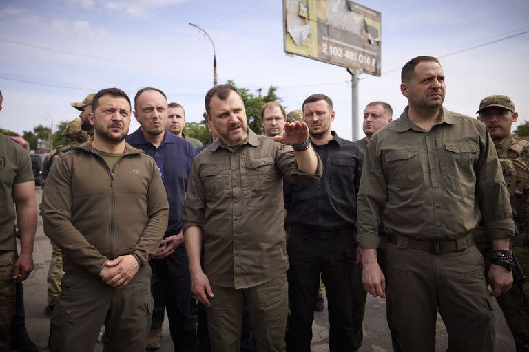 En esta foto proporcionada por la Oficina de Prensa Presidencial de Ucrania, el presidente ucraniano Volodimir Zelenskyy, a la izquierda, visita las áreas afectadas por las inundaciones en Kherson, Ucrania, el jueves 8 de junio de 2023