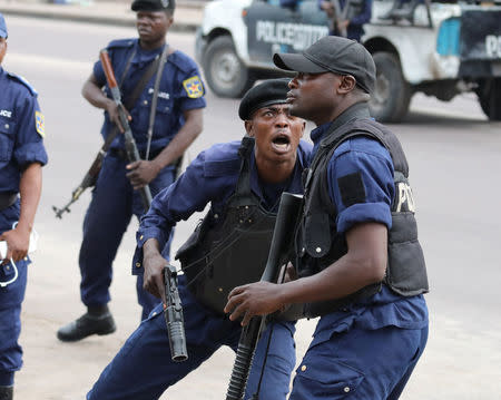 A Policeman reacts after a protester threw a stone from Notre Dame Cathedral compound in Kinshasa, Democratic Republic of Congo, February 25, 2018. REUTERS/Goran Tomasevic