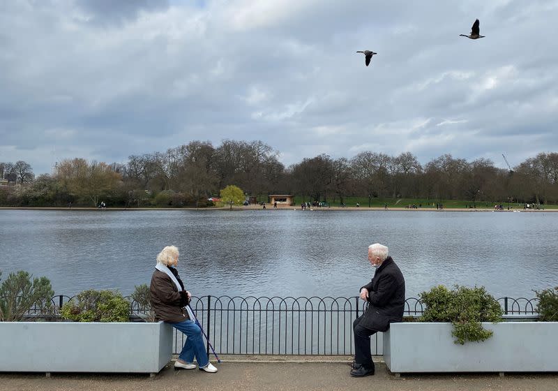 FILE PHOTO: Two people are seen socially distancing as they chat together in Hyde Park, London