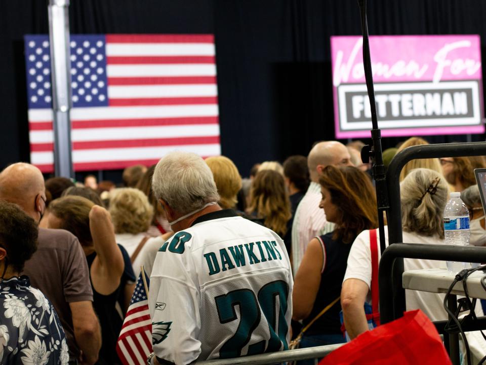 man wearing Eagles jersey in crowd at rally