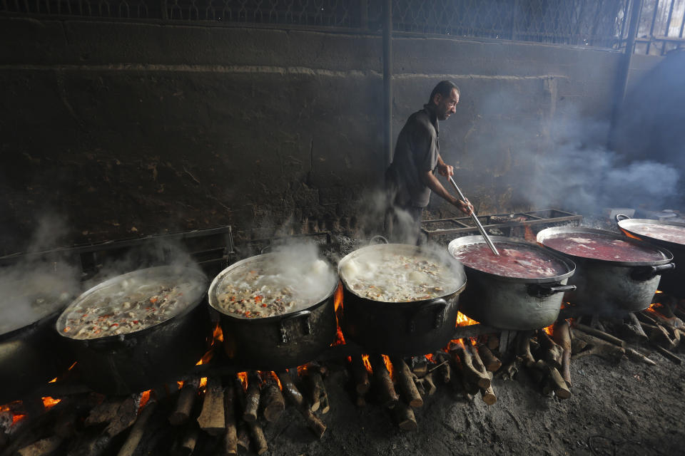 A Palestinian cooks food for people displaced in the ongoing Israeli bombardment of the Gaza Strip in Rafah on Saturday, Oct. 28, 2023.AP Photo/Hatem Ali)