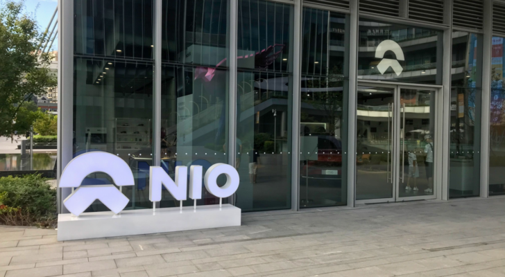 NIO logo and the Nio's user center, NIO House. Retail display of store at downtown LCM mall daytime NIO is a Chinese electric car brand sales person and customers inside