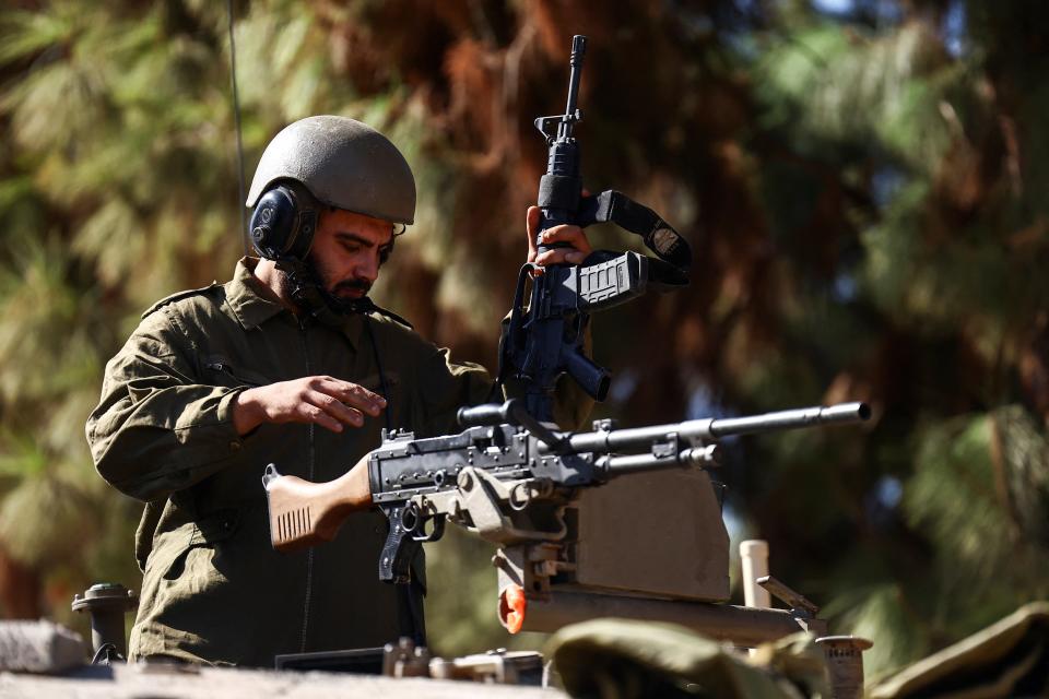 An Israeli soldier operates a firearm in an armoured vehicle near Israel’s border with Lebanon (REUTERS)