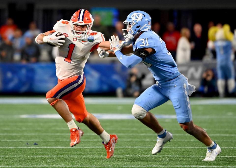 Dec 3, 2022; Charlotte, North Carolina, USA; Clemson Tigers running back Will Shipley (1) stiff arms North Carolina Tar Heels defensive back Will Hardy (31) during the first quarter of the ACC Championship game at Bank of America Stadium. Mandatory Credit: Bob Donnan-USA TODAY Sports
