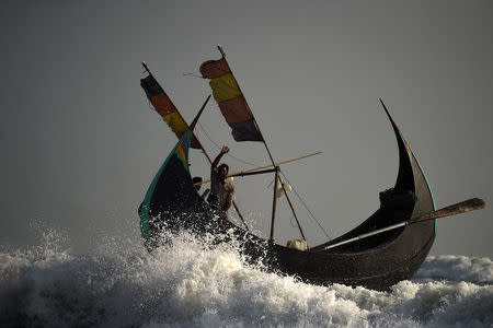 Rohingya refugees crew a fishing boat from Shamlapur beach heading out to the Bay of Bengal near Cox's Bazaar, Bangladesh, March 21, 2018. The boat is unstable in rough seas due to its shape when it hits the waves. REUTERS/Clodagh Kilcoyne .