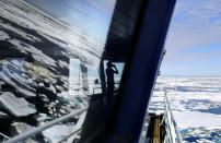 Trainee David Kullualik, of Iqaluit, Nunavut, of Canada's northern territories, looks through binoculars from the bridge of the Finnish icebreaker MSV Nordica as it sails through ice floating on the Chukchi Sea off the coast of Alaska while traversing the Arctic's Northwest Passage, Sunday, July 16, 2017. (AP Photo/David Goldman)