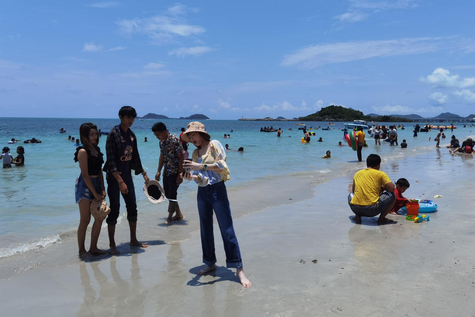 People spend the first day of the Songkran New Year holidays at Nang Rong beach in Chonburi, Thailand Tuesday, April 13, 2021. Thailand on Tuesday recorded almost 1,000 cases for the third straight day, as health officials worry that the number of new infections could be far higher after this week's traditional Thai New Year holiday. (AP Photo / Penny Yi Wang)