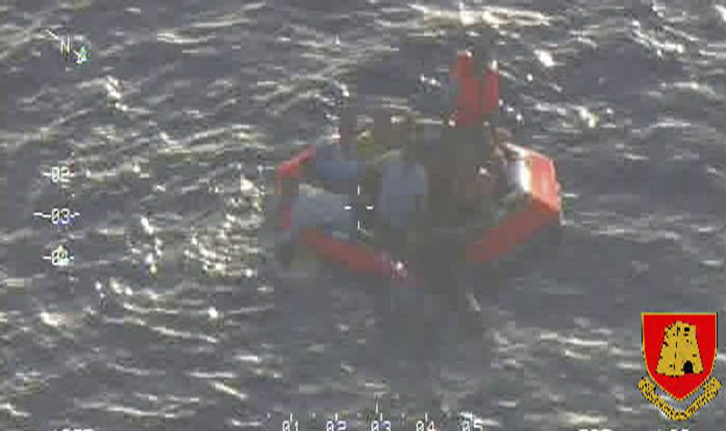 Migrants climb aboard a life raft deployed by an Armed Forces of Malta aircraft