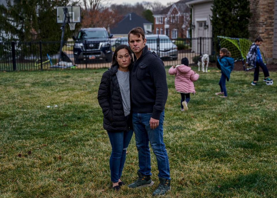 Ellie and Chris Hawkins, parents of three children, stand in front of their home in Chesterfield, Missouri. The Hawkins' family car, a 2018 Chrysler Pacifica Plug-In Hybrid Electric van caught fire while turned off and plugged into the charger in November 2023.