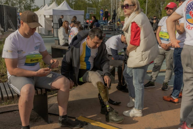 Artem Moroz (C), 45 ans, soldat ukrainien amputé après avoir été blessé au front se prépare pour une course de soldats qui ont connu le même sort afin de récolter des fonds pour l'armée, à Kiev le 14 avril 2024 (Roman PILIPEY)