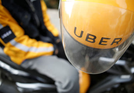 An Uber motorcycle taxi driver waits for customers next to a shopping mall in Jakarta, Indonesia September 20, 2017. REUTERS/Darren Whiteside