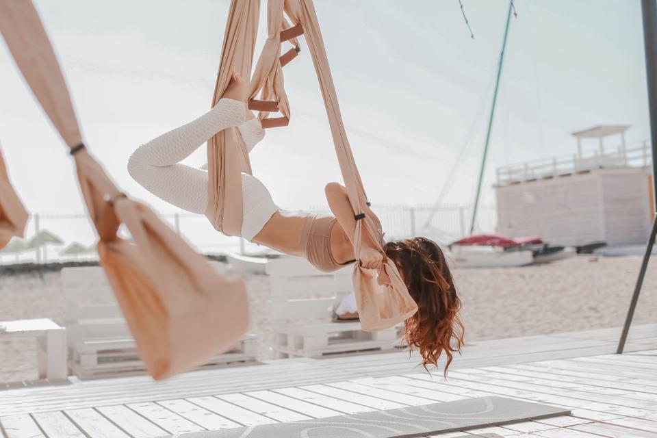 <p>Man sitzt, hängt oder liegt in einem stabilen Tuch = Hängematten-Feeling! Man schwebt in der Luft und lässt die Schwerkraft arbeiten. Wenn Aerial Yoga kein perfekter Sport für Faule ist, dann wissen wir auch nicht! (Bild: iStock/Elena Batkova)</p> 