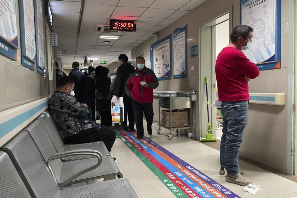 Visitors wait in the emergency department at the Baoding No. 2 Central Hospital in Zhuozhou city in northern China's Hebei province on Wednesday, Dec. 21, 2022. China only counts deaths from pneumonia or respiratory failure in its official COVID-19 death toll, a Chinese health official said, in a narrow definition that limits the number of deaths reported, as an outbreak of the virus surges following the easing of pandemic-related restrictions. (AP Photo)