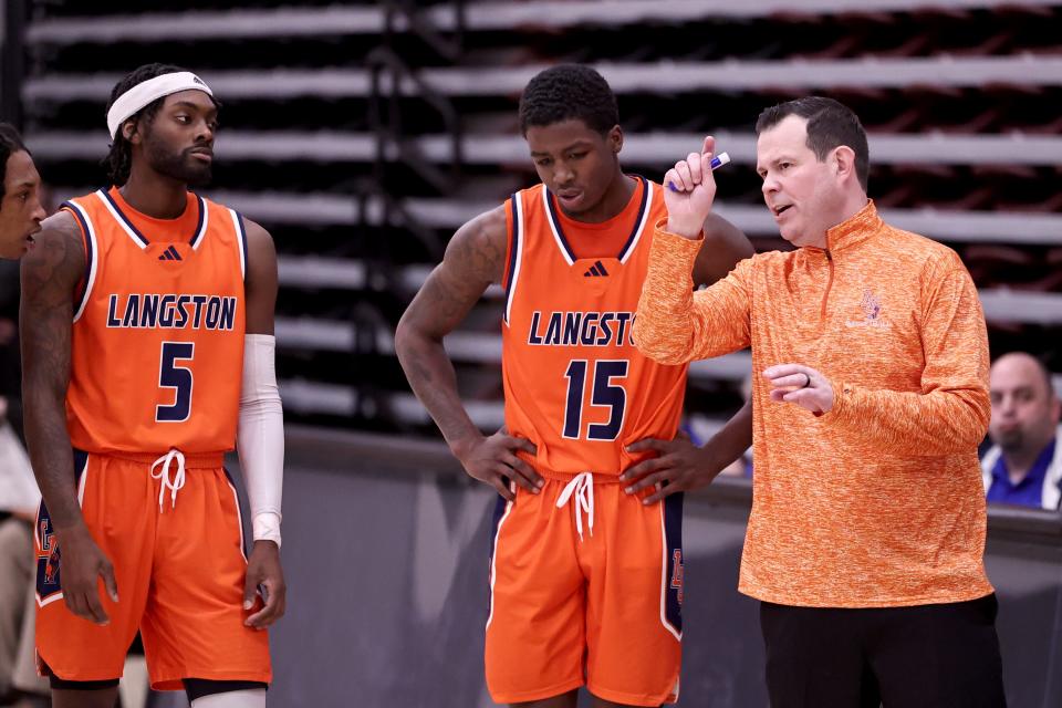 Langston men's basketball coach Chris Wright, right, talks with guard Anthony White (5) and forward Cortez Mosley (15).