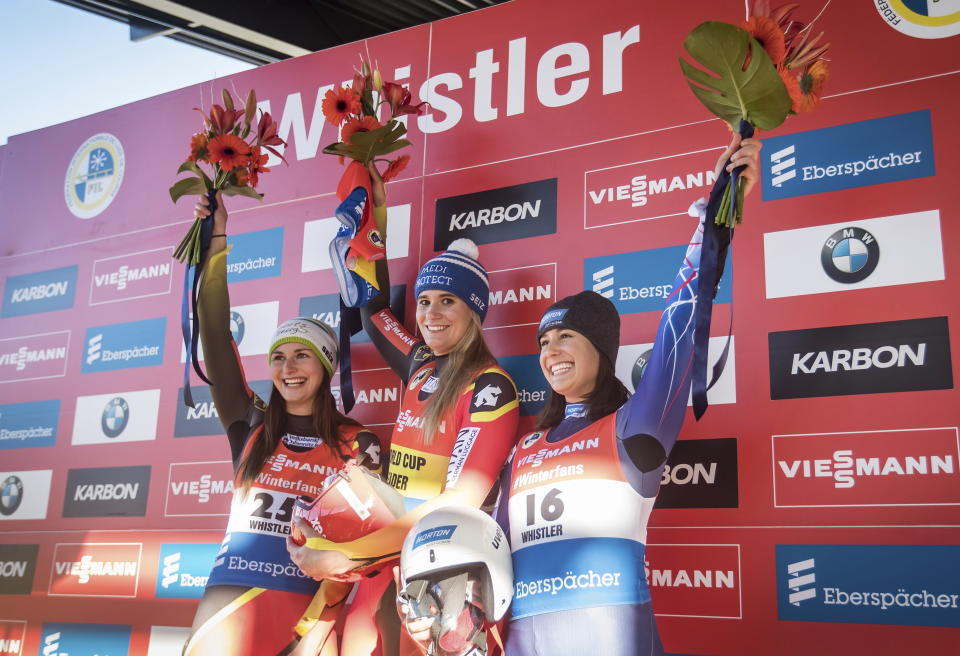 First-place finisher Germany's Natalie Geisenberger, centre, is flanked by second place Julia Taubitz, of Germany, and third place Emily Sweeney, right, of the United States, as they celebrate during a World Cup women's luge event in Whistler, British Columbia, on Saturday, Dec. 1, 2018. (Darryl Dyck/The Canadian Press via AP)