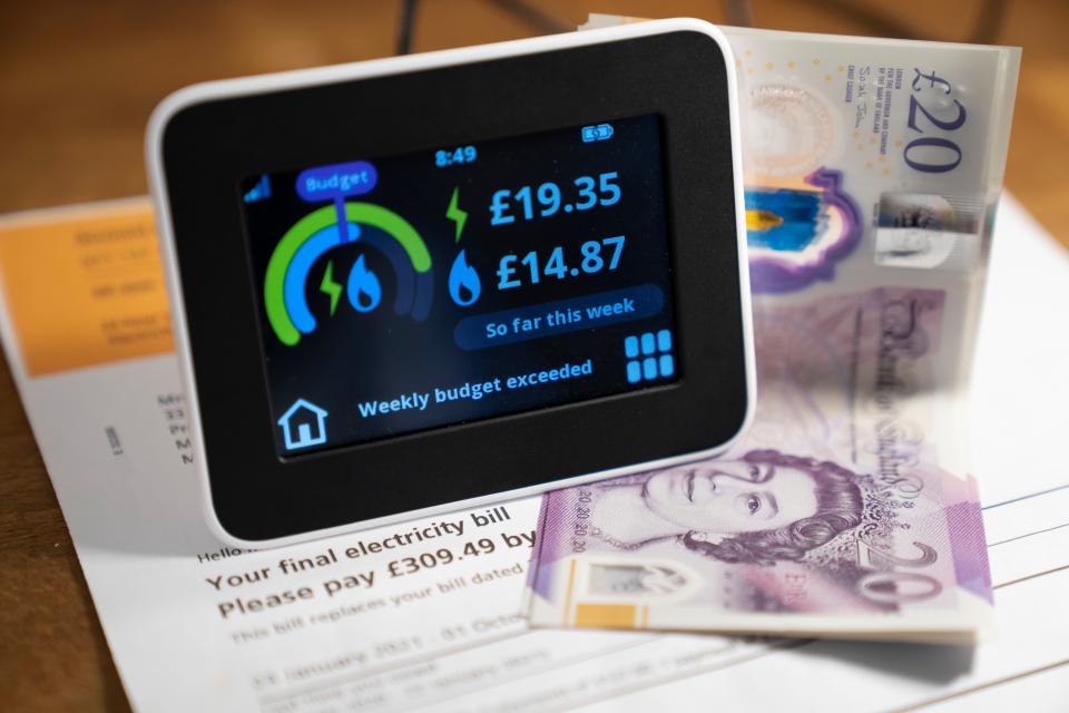 An energy meter, an electricity bill and some notes are seen in a family home in Manchester, Britain