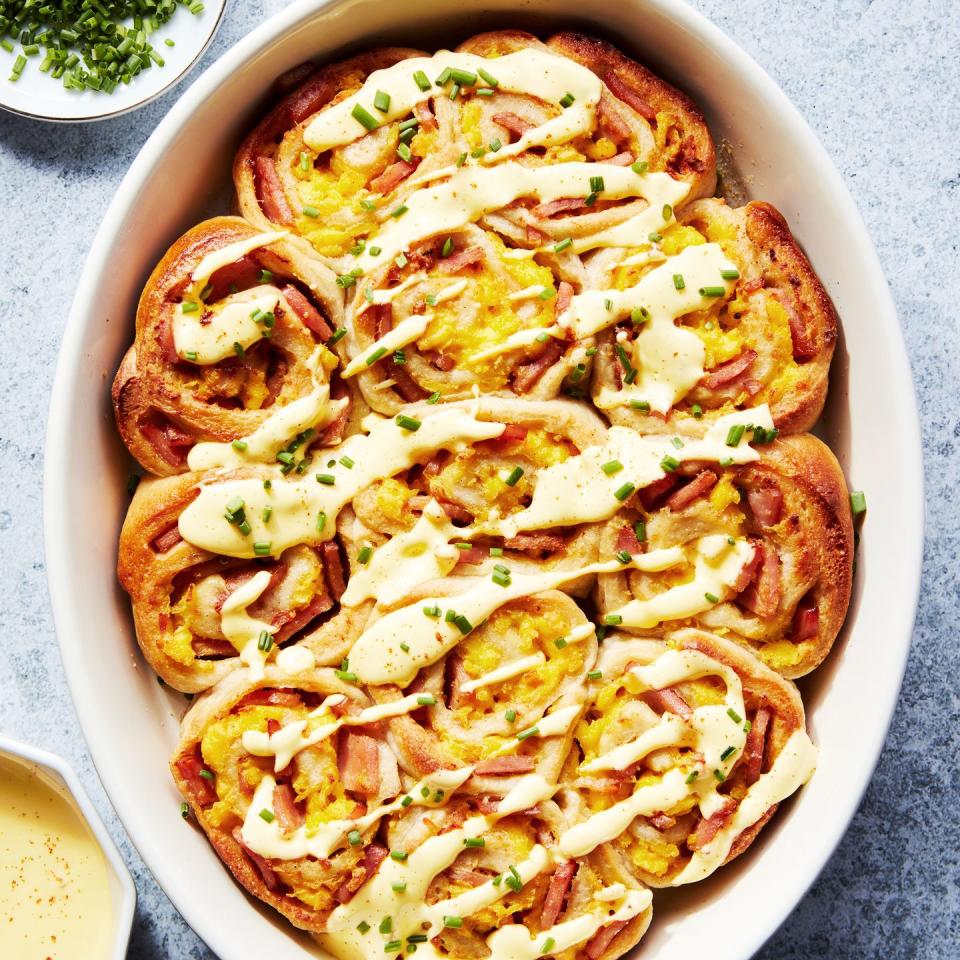 pinwheel style rolls baked in a casserole dish and topped with hollandaise