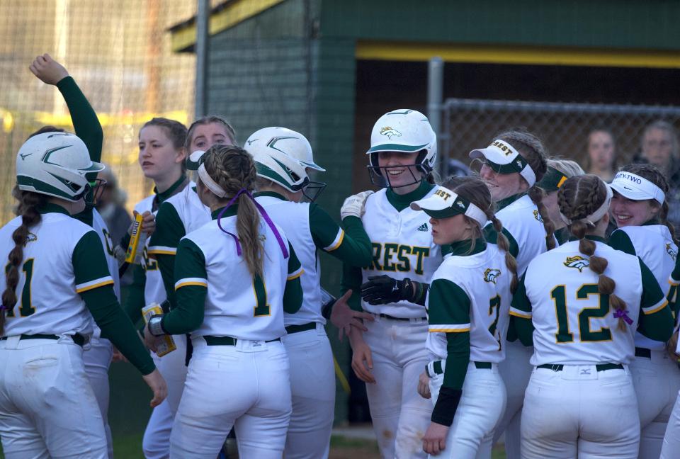 Crest softball players celebrate after a home run during their March 25 win over North Gaston.