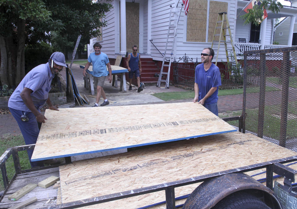 George Raspberry, of R&S Masonry and Justin Martin, of Local Builders, work to install plywood panels on a house at the 600-block of Pollock Street in historic New Bern, N.C., September 4, 2019. Residents are preparing for storm weather before the reported arrival of Hurricane Dorian. (Gray Whitley/Sun Journal via AP)