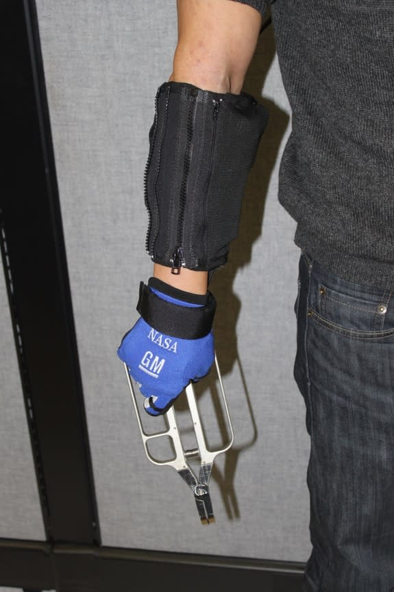 Demonstration of RoboGlove — spinoff technology from NASA's Robonaut program — providing assistance with a grasping task.