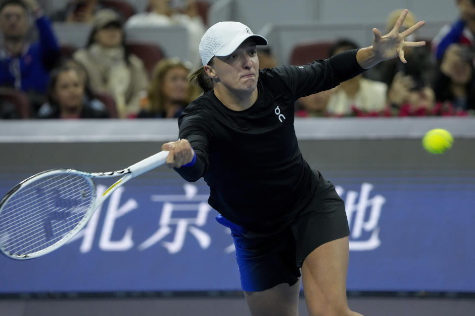 Iga Swiatek of Poland returns a shot to Liudmila Samsanova of Russia during the women's singles final match in the China Open tennis tournament at the Diamond Court in Beijing, Sunday, Oct. 8, 2023. (AP Photo/Andy Wong)