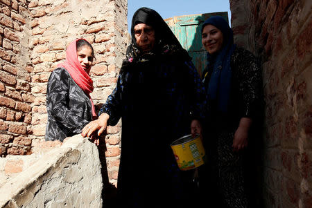 Mageda (C), 80, walks with her granddaughters Esraa Salah (R), 15, and Nada, 14, at the rooftop of their home in Alwasata village of Assiut Governorate, south of Cairo, Egypt, February 8, 2018. REUTERS/Hayam Adel/Files