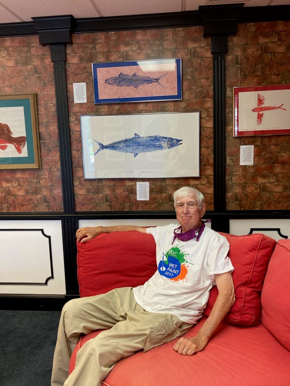 Middletown artist and angler Tony Chatowsky sits in front of his unique fish print artwork, made using a traditional Japanese technique.