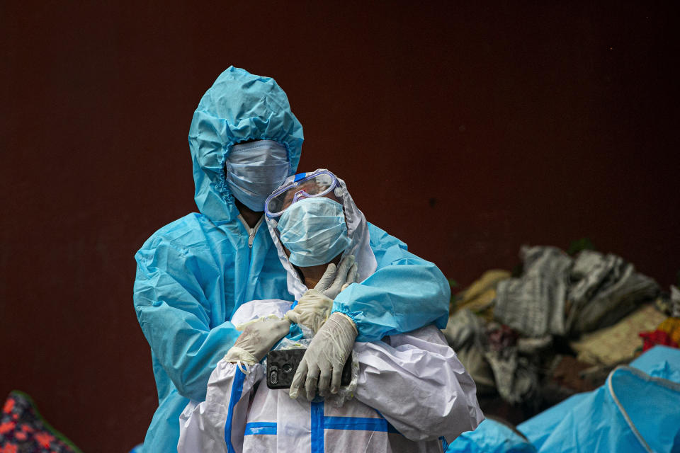 FILE - A woman wearing white protective gear mourns after a glimpse of her husband's body, a victim of COVID-19, at a cremation ground in Gauhati, India, Thursday, Sept. 10, 2020. (AP Photo/Anupam Nath, File)