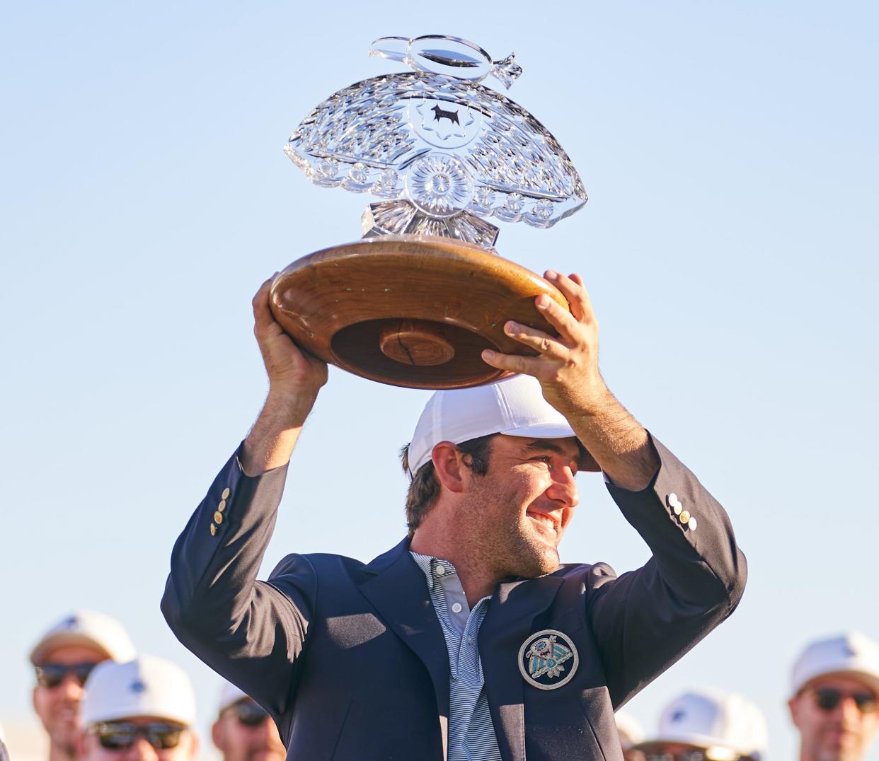 Feb. 13, 2022; Scottsdale Arizona, USA; Scottie Scheffler holds the WM Phoenix Open trophy over his head after winning the WM Phoenix Open. Mandatory Credit: Alex Gould - The Republic