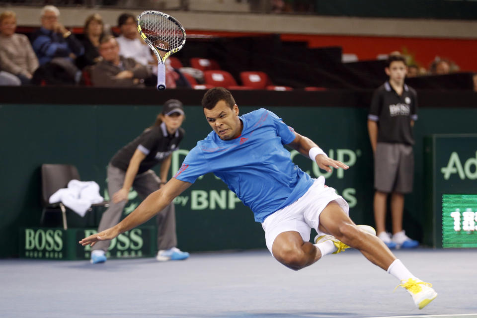 Jo Wilfried Tsonga of France falls during his first round Davis Cup tennis match against Amir Weintraub of Israel in Rouen, February 1, 2013. REUTERS/Charles Platiau (FRANCE - Tags: SPORT TENNIS) - RTR3D8BW