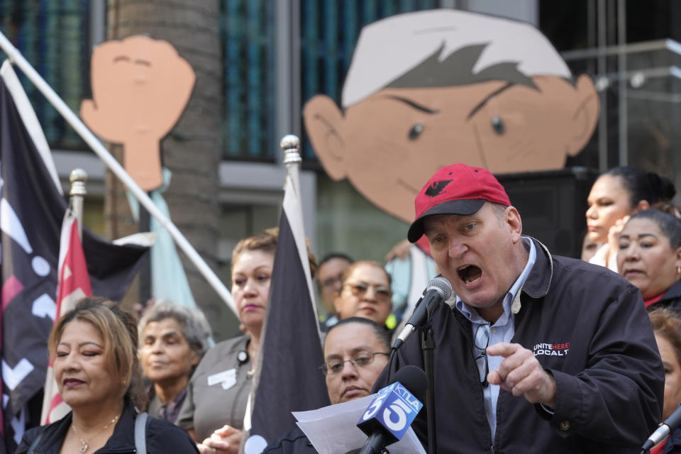 Unite Here Local 11 Co-President Kurt Petersen, at podium, congratulates hotel workers and leaders as he announces the ratification results and unveiled the new contract terms at a news conference on the steps of the Intercontinental Hotel downtown in Los Angeles, Monday, March 25, 2024. (AP Photo/Damian Dovarganes)