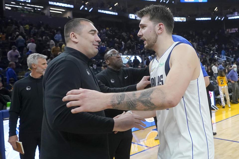 Golden State Warriors assistant coach Dejan Milojevic, foreground left, greets Dallas Mavericks guard Luka Doncic after an NBA basketball game in San Francisco, Sunday, Feb. 27, 2022. Warriors assistant coach Dejan Milojević, a mentor to two-time NBA MVP Nikola Jokic and a former star player in his native Serbia, died Wednesday, Jan. 17, 2024, after suffering a heart attack, the team announced. Milojević, part of the staff that helped the Warriors win the 2022 NBA championship, was 46. (AP Photo/Jeff Chiu)