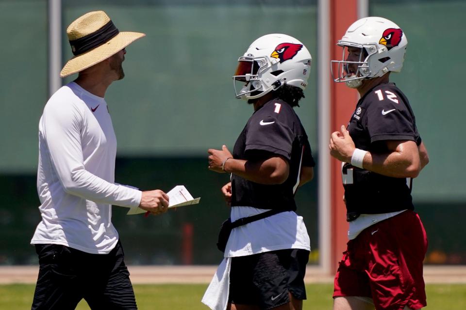 Arizona Cardinals' Kyler Murray (1) and Colt McCoy run past head coach Kliff Kingsbury during the team's NFL football practice, Wednesday, June 1, 2022, in Tempe, Ariz. (AP Photo/Matt York)