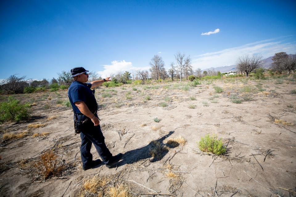 Fire Capt. Joseph Mayorga points to an area where he found a dying migrant just a few hundred yards from a home in Sunland, Park New Mexico.