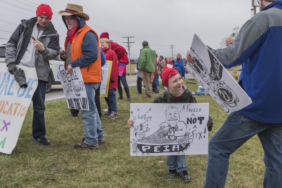 <p>Ivan Weikle makes a face at his father while holding a sign in support of PEIA drawn by Lewisburg Elementary School art teacher Jody Wilber (in hat) along Route 219 in Lewisburg, W.Va., on Monday, Feb. 26, 2018 on the third day of the statewide walkout by school personnel. (Photo: Craig Hudson /Charleston Gazette-Mail via AP) </p>