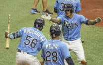 Tampa Bay Rays' Randy Arozarena (56) and Francisco Mejia (28) congratulate Willy Adames after his two-run home run off New York Mets' Marcus Stroman during the fifth inning of a baseball game Sunday, May 16, 2021, in St. Petersburg, Fla. (AP Photo/Steve Nesius)