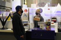 A server tends to a customer at the Grand Central Market Monday, Nov. 16, 2020, in Los Angeles. California Gov. Gavin Newsom announced Monday, Nov. 16, 2020, that due to the rise of COVID-19 cases, Some counties have been moved to the state's most restrictive set of rules. The new rules begin, Tuesday, Nov. 17. (AP Photo/Marcio Jose Sanchez)