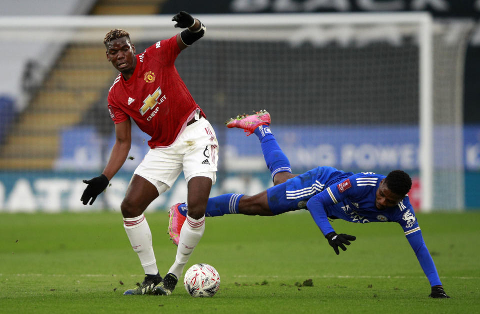 Manchester United's Paul Pogba, left, duels for the ball with Leicester's Kelechi Iheanacho during the English FA Cup quarter final soccer match between Leicester City and Manchester United at the King Power Stadium in Leicester, England, Sunday, March 21, 2021. (AP Photo/Ian Walton, Pool)