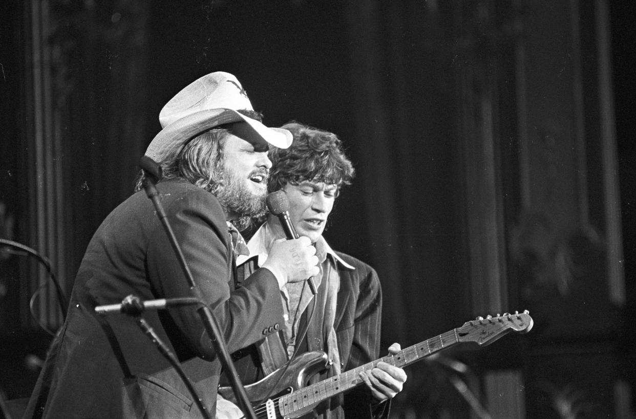 Musicians Ronnie Hawkins and Robbie Robertson (playing a Fender Stratocaster electric guitar) perform on stage at The Band's 'The Last Waltz' concert at Winterland Ballroom on November 25, 1976 in San Francisco, California. 