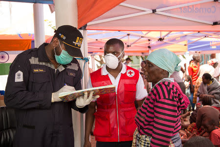 Rescue workers talk with a survivor of Cyclone Idai, at an evacuation centre in Beira, Mozambique, March 21, 2019. Denis Onyodi/Red Cross Red Crescent Climate Centre/Handout via REUTERS