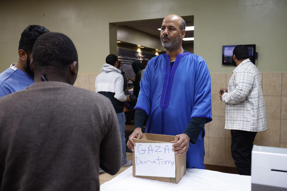 Brahim Chakrani collects donation for Gaza following Friday prayers, Friday, Oct. 13, 2023, at the Islamic Center of East Lansing in East Lansing, Mich. In Muslim communities across the world, worshippers gathered at mosques for their first Friday prayers since Hamas militants attacked Israel, igniting the ongoing Israel-Hamas war. (AP Photo/Al Goldis)