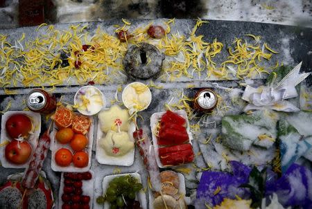 Food dedicated to Fan Guohui and Zheng Qing’s dead son, Fan Lifeng, are placed on the altar as they show reporters his grave during their visit to the graveyard in Zhangjiakou, China, November 22, 2015. Fan Lifeng, the son of Fan Guohui and his wife Zheng Qing, both aged 56, was born in 1984 and died from a car accident in 2012. Fan Guohui has petitioned the government to give "shidu" parents, those whose only child has died, moral and financial support. Zheng Qing said the couple was "emotionally ruined". China scrapping its one-child policy has deepened the sorrow of some parents whose only child has died, in a country where children traditionally look after their parents in old age. REUTERS/Kim Kyung-Hoon