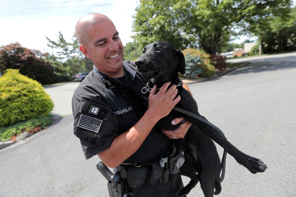 Captain Paul Douglas of the Bristol County House of Correction K-9 unit thanks his dog Huntah for doing a great job in her COVID-19 sniffing exercise.