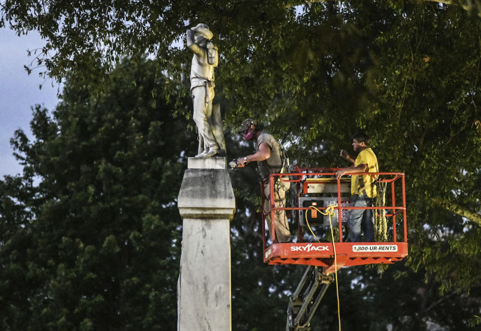 Workers prepare to move the Confederate statue located in the Circle at the University of Mississippi to the Confederate Soldiers Cemetery, in Oxford, Miss. Tuesday, July 14, 2020. (Bruce Newman)/The Oxford Eagle via AP)